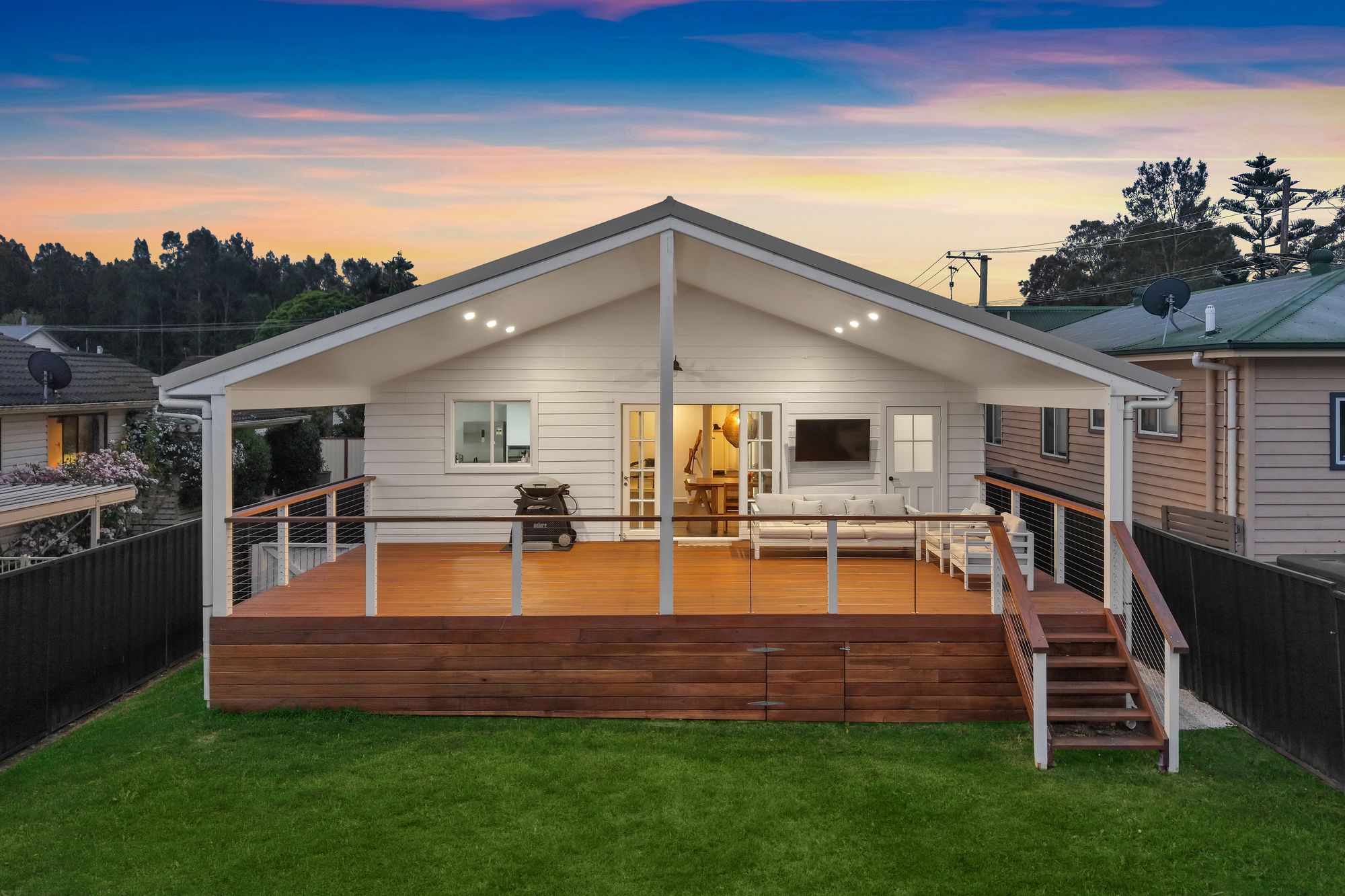 Rear of a covered deck lit at dusk
